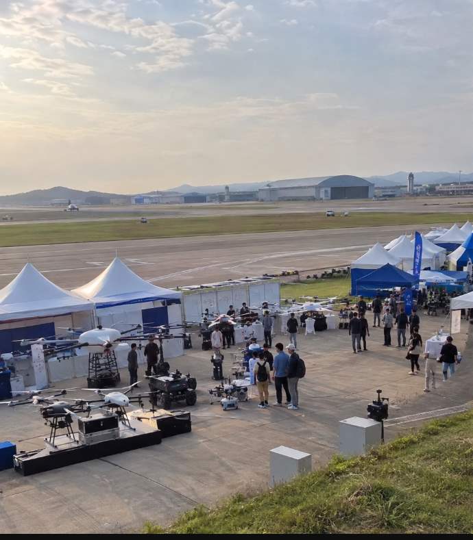 Yangju DroneBot Festival visitors boarding a shuttle bus from the Yangju Culture & Arts Center parking lot
