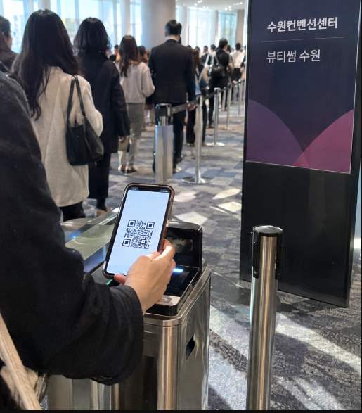 수원컨벤션센터 등록 데스크에서 QR코드로 사전등록을 확인하는 장면